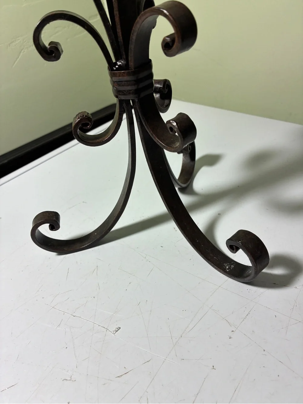 vintage wrought iron candle holder features a dark metal scroll and ring design